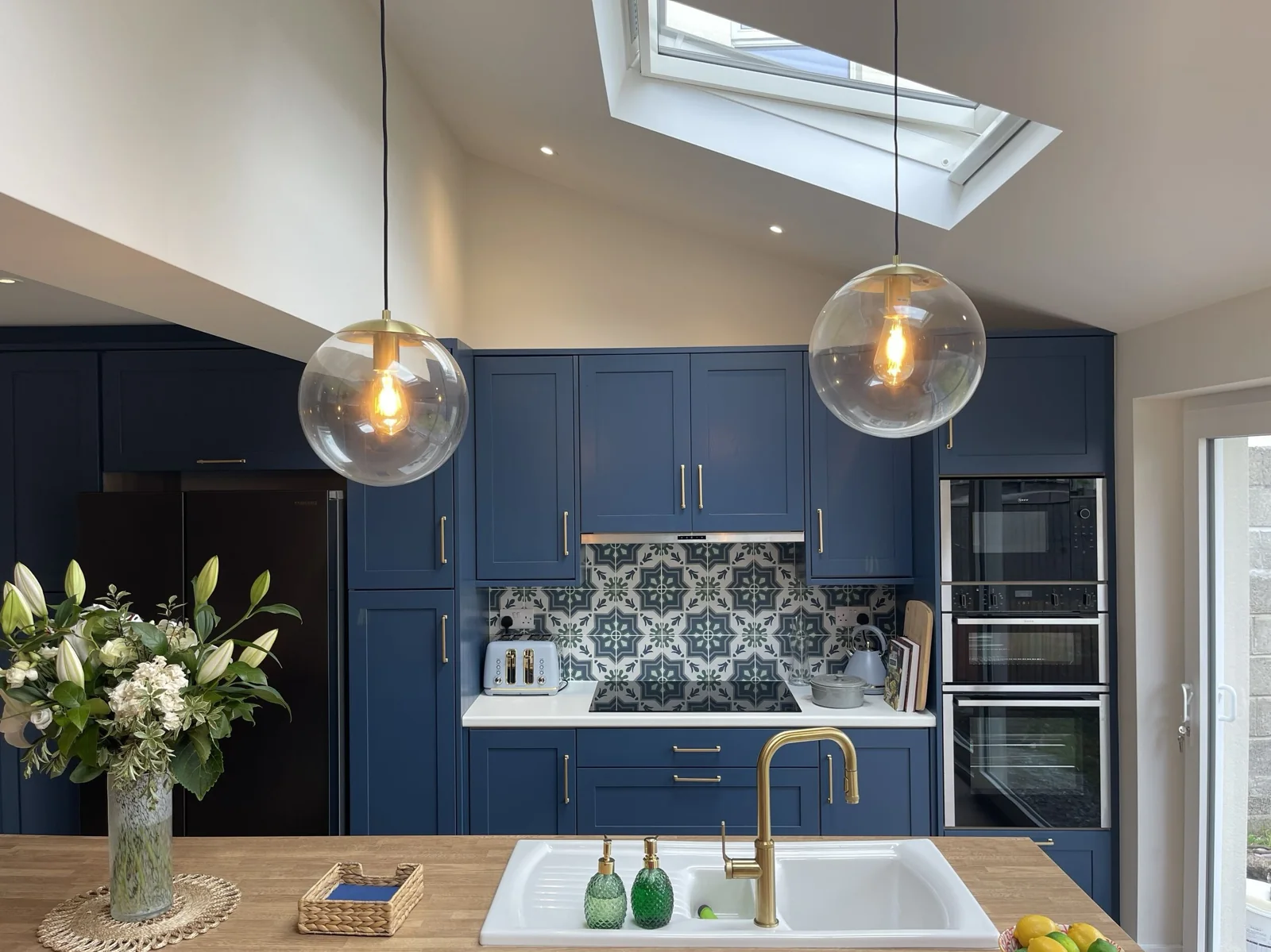 Blue kitchen cabinetry beneath a rooflight in Mount Merrion